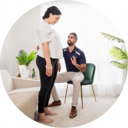 Physiotherapist and patient being pictured, the physiotherapist is guiding the patient to stand up,